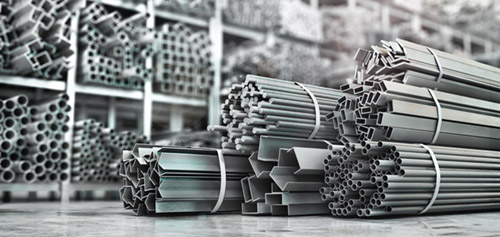 Stacked steel beams and metal profiles used in construction restoration and project management.