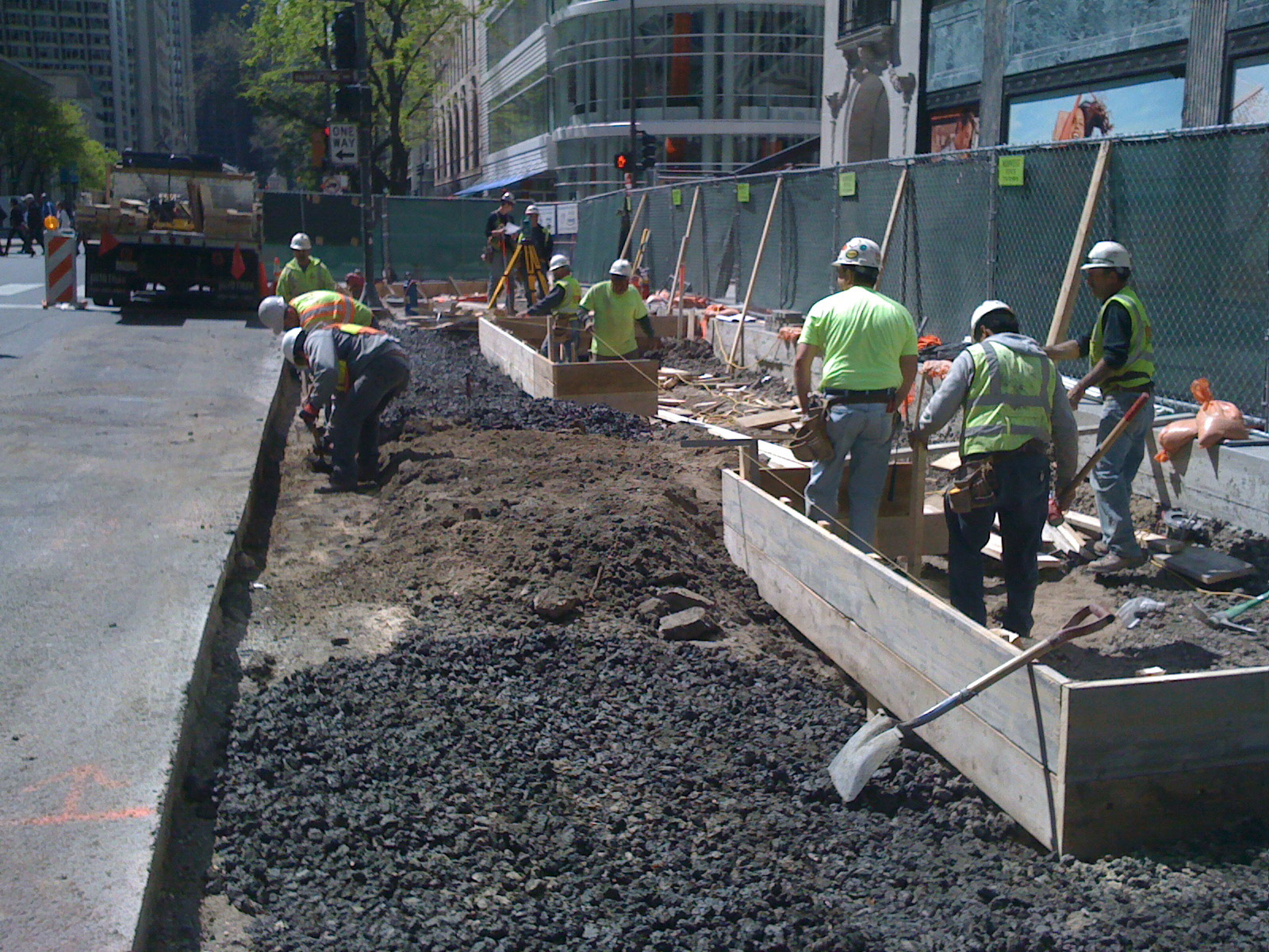 Crew performing concrete and foundation repair with formwork and excavation on busy Chicago street.